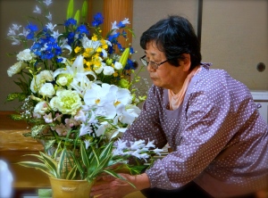 Flowers for her husband.2 Hitoko arranges flowers for the 49 day ceremony.  Himeji. 2015.